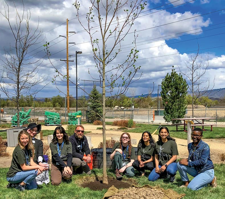 Photo of volunteers gathered around a tree they planted