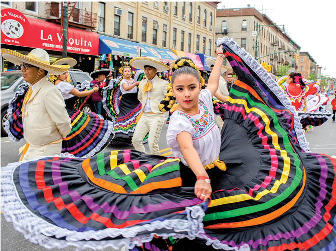 People wearing cultural clothing and dancing in the city streets