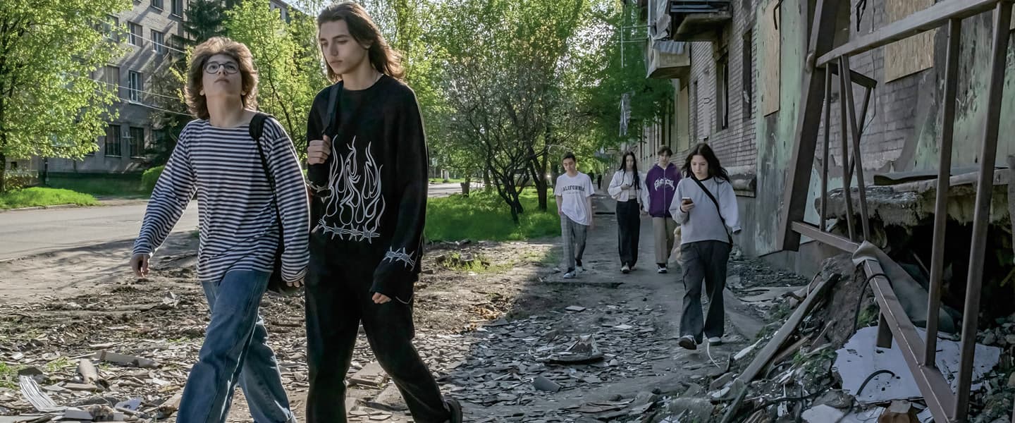 Image of students walking from school among rubble