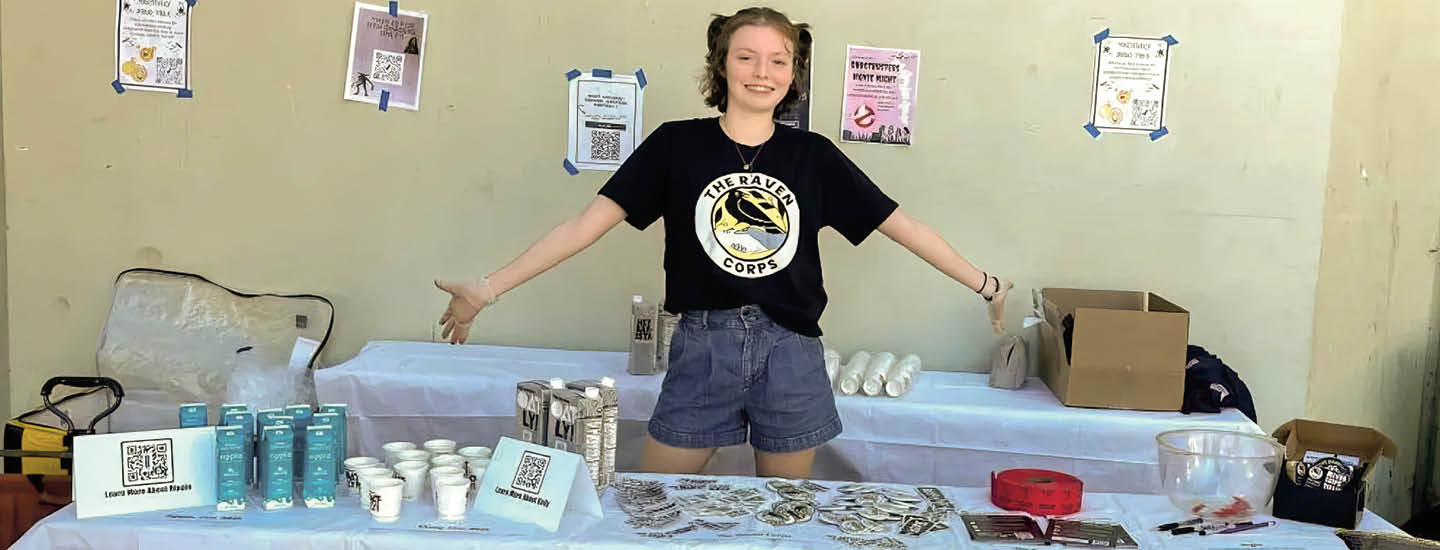 Image of a person posing in front of a table of supplies