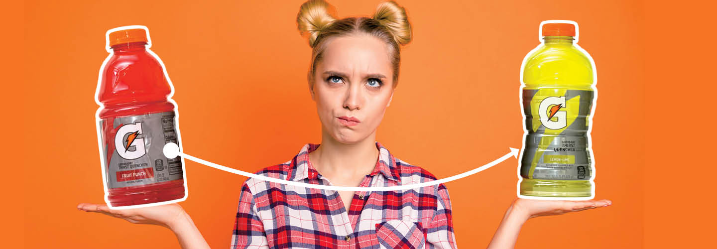 a girl holding two different sized bottles of Gatorade